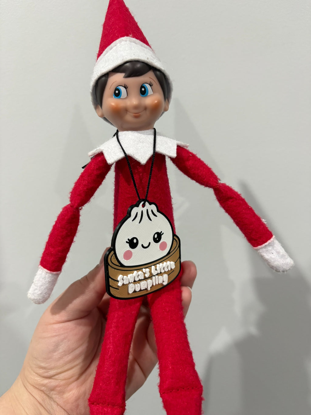 Santa's Little Dumpling necklace worn by a Christmas elf doll