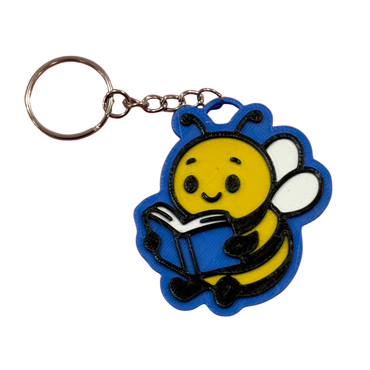 3D printed Reading Bee keyring with a yellow bee holding a blue book on a blue outline background